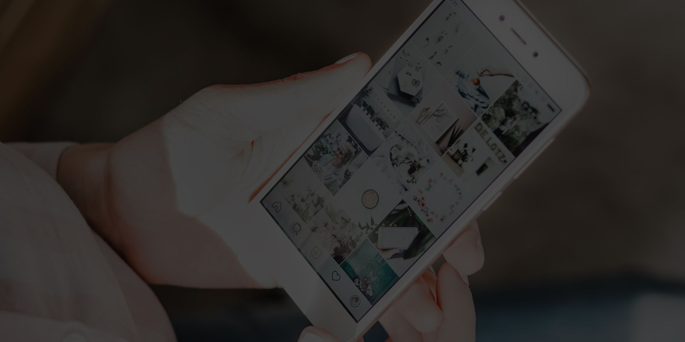 Person holding smartphone displaying photo gallery.