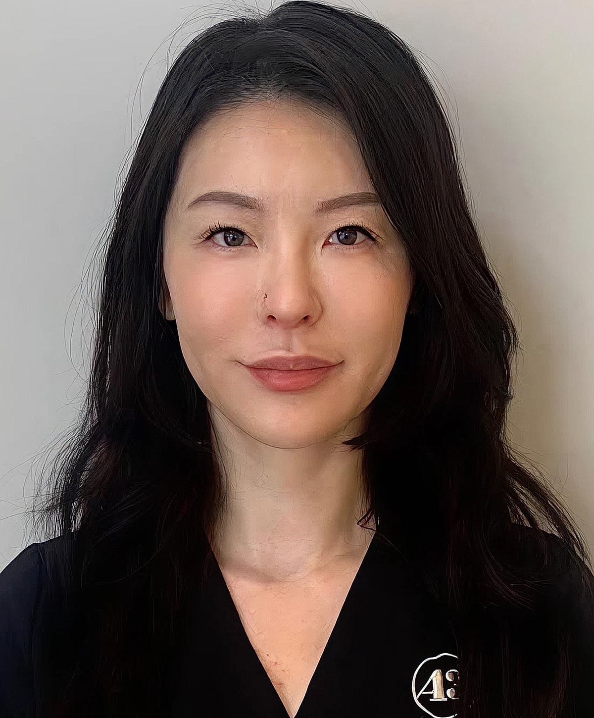 Woman with black hair wearing a dark top.