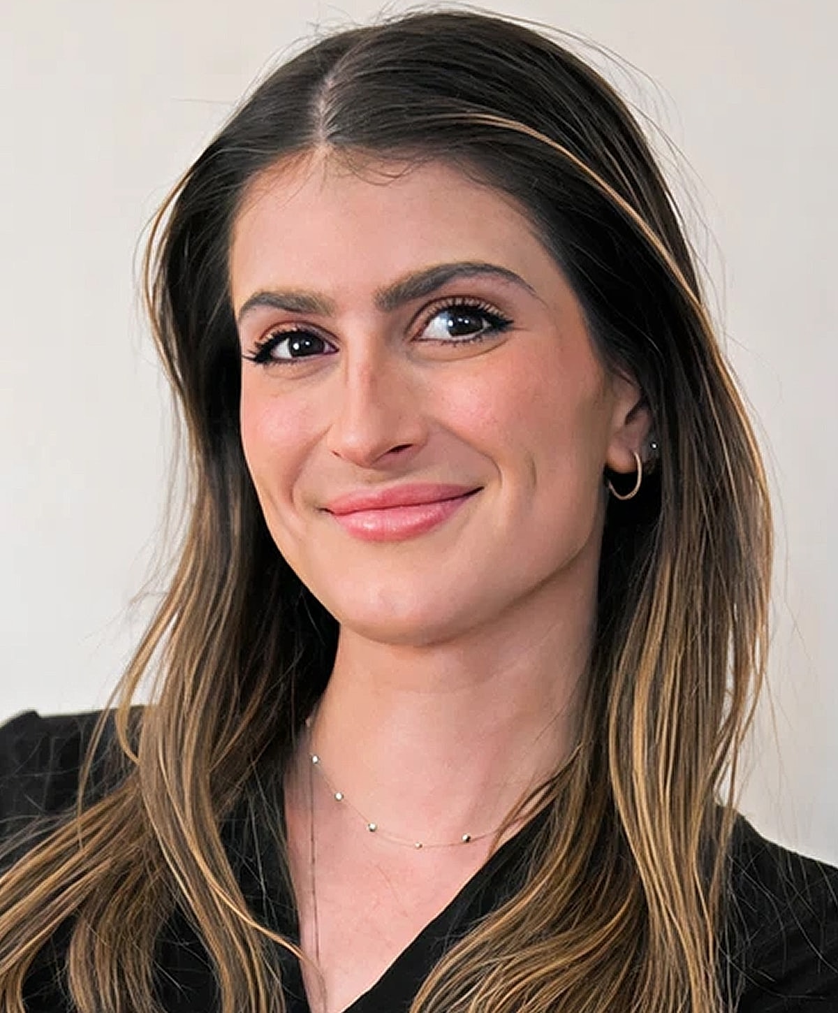 Smiling woman with long hair and necklace.